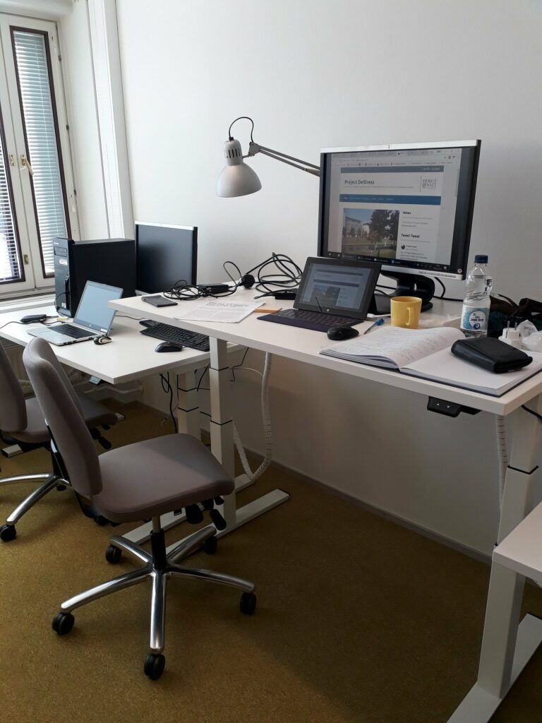 office standing desk with computer screen showing DeStress website