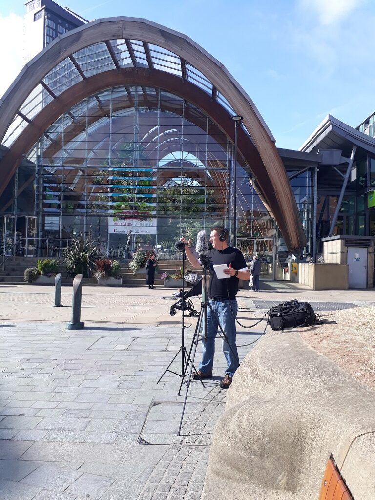 Sheffield public square with Neil examining sound level meter on a tripod